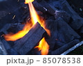 Fire on logs in fire pot with embers and burning coal and blazing flames. 85078538