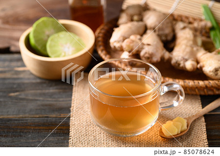 Ginger tea with lime and honey on wooden background, Healthy herbal drink 85078624