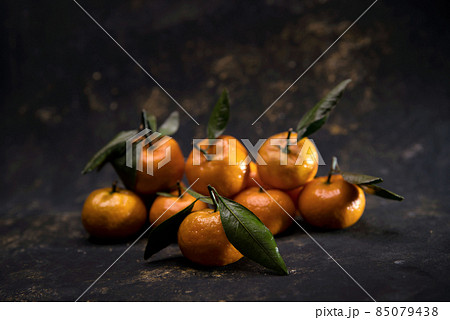 Bright orange Tangerines on black background Bright orange Tangerines on black background 85079438