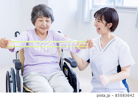 介護イメージ　ゴムチューブで運動するシニア女性と理学療法士　撮影協力：中央工学校附属日本語学校 85083642