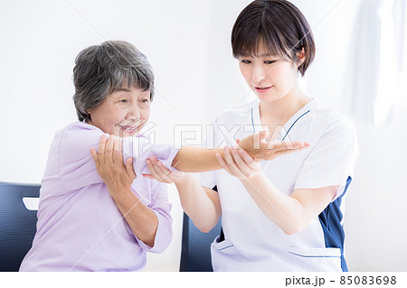 医療　腕のリハビリをするシニア女性と理学療法士　撮影協力：中央工学校付属日本語学校 85083698