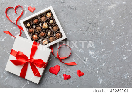 Delicious chocolate pralines in red box for Valentine's Day. Heart shaped box of chocolates top view with copy space Delicious chocolate pralines in red box for Valentine's Day. Heart shaped box of chocolates top view with copy space 85086501
