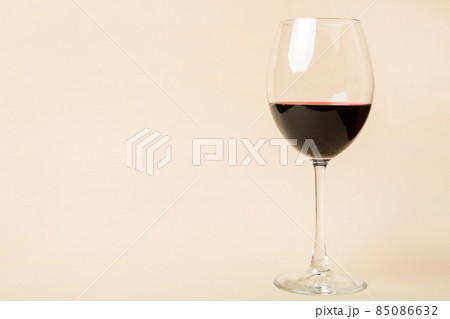 One glasses of red wine at wine tasting. Concept of red wine on colored background. Top view, flat lay design One glasses of red wine at wine tasting. Concept of red wine on colored background. Top view, flat lay design 85086632