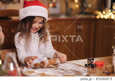 Making gingerbread at home. Little girl cutting cookies of gingerbread dough. Christmas and New Year traditions concept. Christmas bakery. Happy holidays 85086873