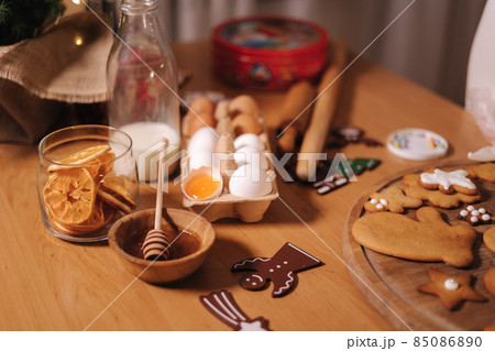 Home bakery, cooking traditional festive sweets. Preparing for making gingerbread dough on wooden table. New Year celebration traditions. Honey and dried orange wedges. Christmas mood 85086890