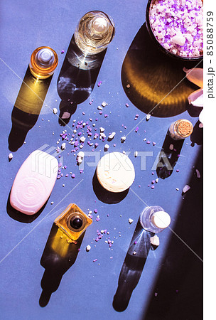 Cosmetic bottles essential oil with contrasting shadows, lotus flower, sea salt. Cosmetic bottles essential oil with contrasting shadows, lotus flower, sea salt. 85088759