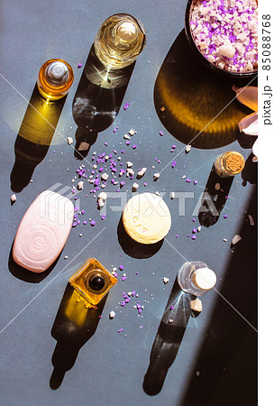 Beauty products, cosmetic bottles with essential oil contrasting shadows on grey, lotus flower, sea salt for bath top view. Spa treatment, wellness, relaxation, body, face care. Beautiful composition Beauty products, cosmetic bottles with essential oil contrasting shadows on grey, lotus flower, sea salt for bath top view. Spa treatment, wellness, relaxation, body, face care. Beautiful composition 85088768
