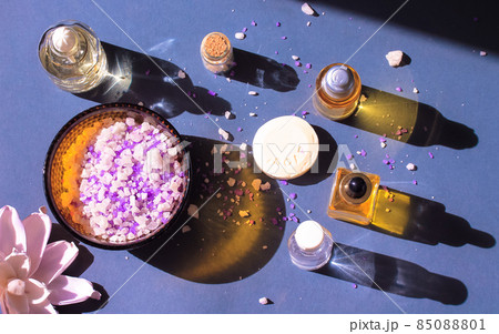 Beauty products, essential oil bottles contrasting shadows, lotus, sea salt bath Beauty products, essential oil bottles contrasting shadows, lotus, sea salt bath 85088801