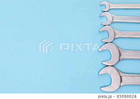 Tools worker, many wrenchs on blue background, top view with free space Tools worker, many wrenchs on blue background, top view with free space 85090028