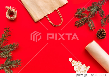 Christmas and new year festive Flat lay mock up gifts making, preparation and wrapping in kraft paper package on red background. 85090984