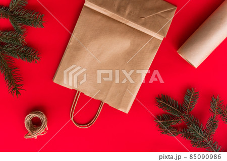 Christmas and new year festive Flat lay mock up gifts making, preparation and wrapping in kraft paper package on red background. Christmas and new year festive Flat lay mock up gifts making, preparation and wrapping in kraft paper package on red background. 85090986