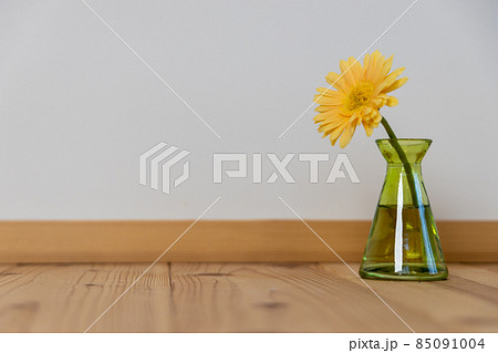 緑色の一輪挿しにさしてある黄色いガーベラの花 85091004