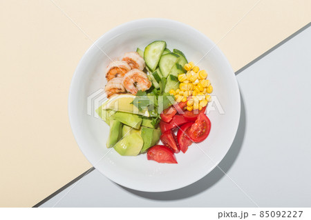 Fresh Avocado, shrimps salad with lettuce green mix, cherry tomatoes, herbs and olive oil, lemon 85092227