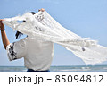 青空の下白いレースを翻す女性 85094812
