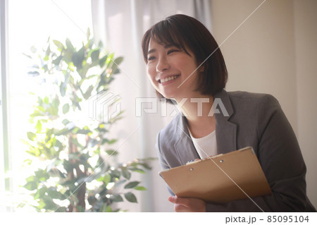 バインダーを持つ笑顔の女性社員 85095104