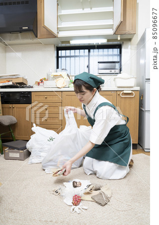 散らかった部屋を片付ける女性作業員 散らかった部屋を片付ける女性作業員 85096677