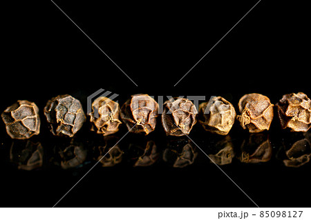 Spicy black pepper on black glass Spicy black pepper on black glass 85098127