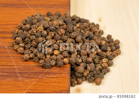 Spicy black pepper on plain wood Spicy black pepper on plain wood 85098162
