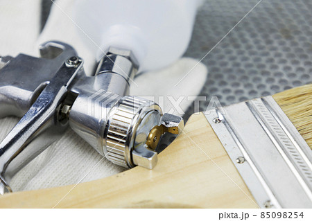 Instructions and a paint spray gun at work at the workplace in the workshop. 85098254