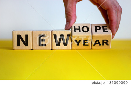 New year and hope symbol. Businessman turns cubes and changes the words 'new year' to 'new hope'. Beautiful white and yellow background. Copy space. Business and new year - new hope concept. New year and hope symbol. Businessman turns cubes and changes the words 'new year' to 'new hope'. Beautiful white and yellow background. Copy space. Business and new year - new hope concept. 85099090