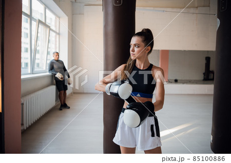 Woman training boxing with personal trainer. Instructor teaching female boxer fighting practice together 85100886