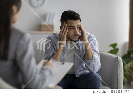 Depression counseling. Desperate arab man telling about unhappy life while female psychologist taking notes Depression counseling. Desperate arab man telling about unhappy life while female psychologist taking notes 85101474