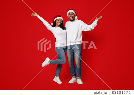 Happy african amerian lovers in Santa hats having fun Happy african amerian lovers in Santa hats having fun 85101576