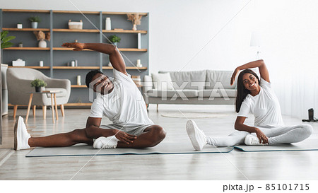 Young black couple doing side bend exercise together Young black couple doing side bend exercise together 85101715