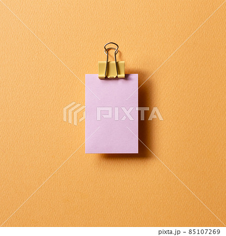 Blank purple sticky note pad and metal clip on orange background. top view, copy space Blank purple sticky note pad and metal clip on orange background. top view, copy space 85107269