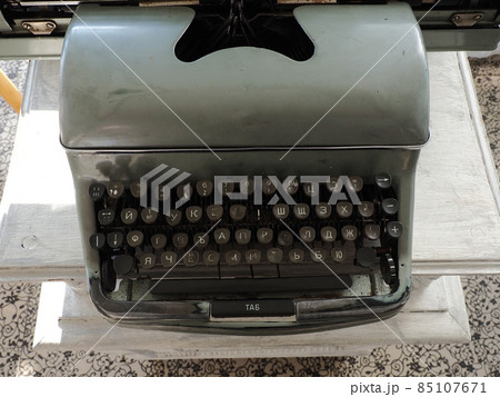 An old gray typewriter with white Cyrillic letters on black keys and one missing key. Closeup photo 85107671