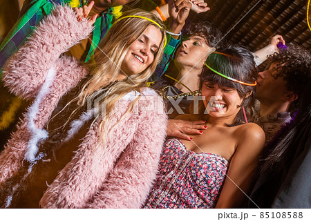 Young women having fun with their friends in a party Young women having fun with their friends in a party 85108588