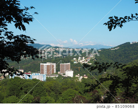 A city in the distance in a green mountain valley on a summer day A city in the distance in a green mountain valley on a summer day 85109068