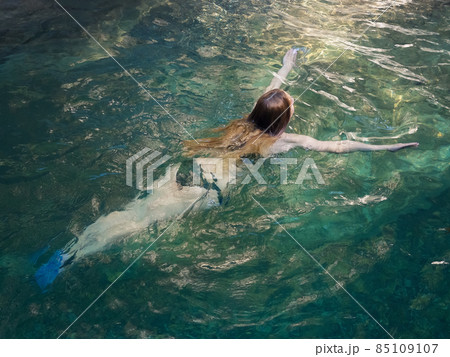 Longhaired girl swimming in clear and transparent turquoise river water. Rest on the river 85109107