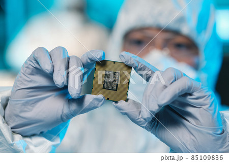 Gloved hands of contemporary scientist holding microchip 85109836