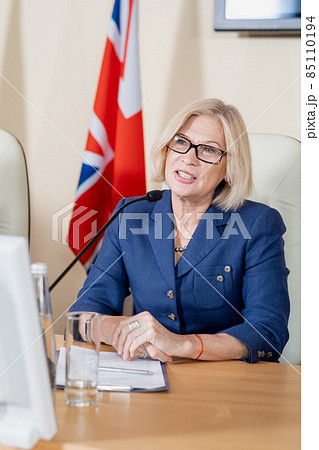 Confident mature blond female delegate speaking at conference 85110194