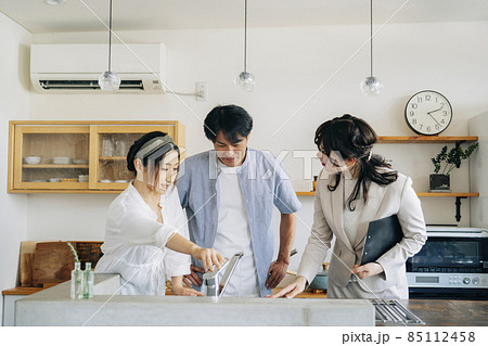 キッチンの設備を説明する女性（水道） 85112458