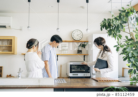 キッチンの設備を説明する女性（レンジ） 85112459