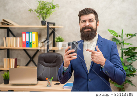 smiling brutal ceo in suit has lunch break point finger on takeaway coffee cup, coffee break. smiling brutal ceo in suit has lunch break point finger on takeaway coffee cup, coffee break. 85113289