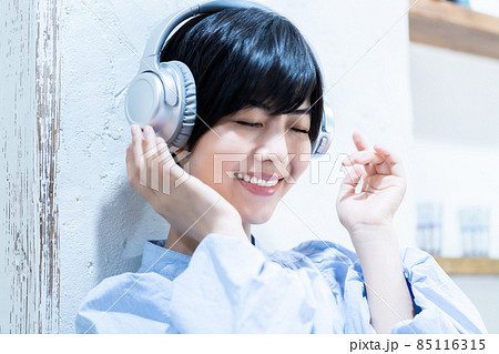 ヘッドフォンで音楽を聴く若い女性 ヘッドフォンで音楽を聴く若い女性 85116315