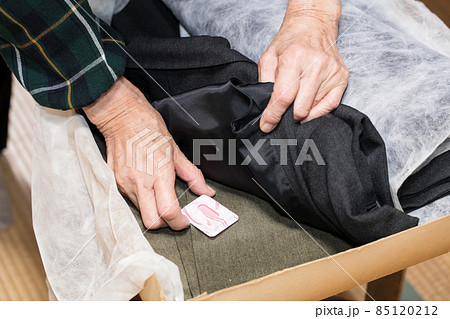 化粧ケースの防虫剤を取り替えるシニア女性 85120212