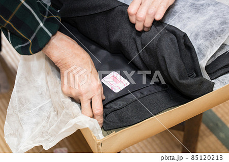 化粧ケースの防虫剤を取り替えるシニア女性 85120213