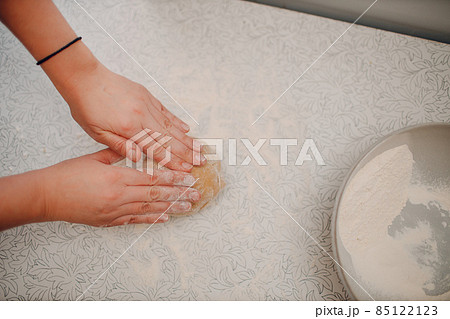 Female hands kneading dough in bowl on table close up. Winter holiday. 85122123