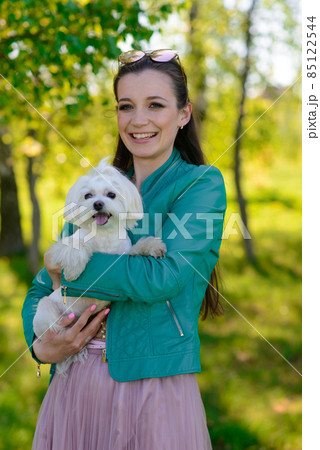 Puppy white dog with it's owner. Concept about friendship, animal and freedom. 85122544