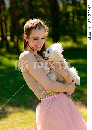 Puppy white dog with it's owner. Concept about friendship, animal and freedom. Puppy white dog with it's owner. Concept about friendship, animal and freedom. 85122546