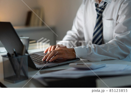 Overwork Concept The man sitting at his desk and focusing on working through his computer laptop Overwork Concept The man sitting at his desk and focusing on working through his computer laptop 85123855