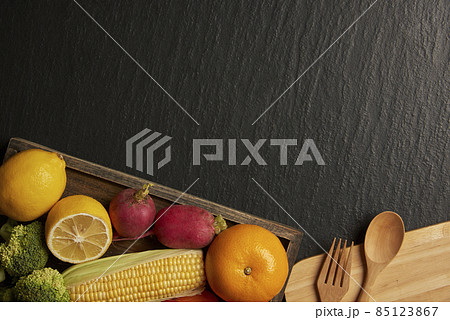 vegetable concept different types of vegetables being set on the wooden cutting board on the dark background vegetable concept different types of vegetables being set on the wooden cutting board on the dark background 85123867
