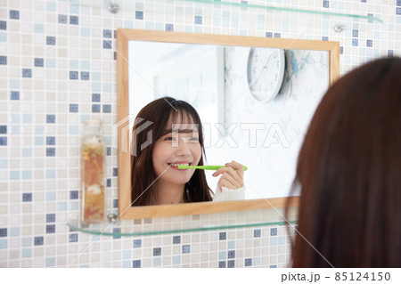 鏡の前で歯磨きをする女性 85124150