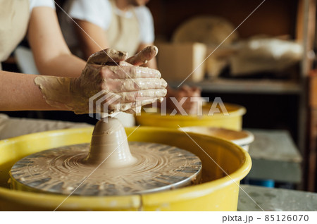 Hands of a potter. Potter making ceramic pot on the pottery wheel Hands of a potter. Potter making ceramic pot on the pottery wheel 85126070