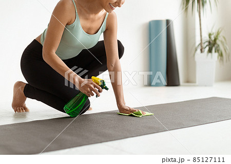 Closeup Shot Of Young Woman Cleaning Yoga Mat Surface Before Training 85127111