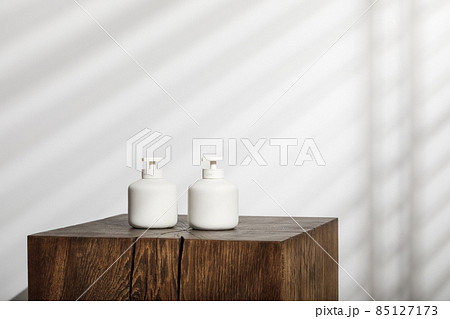 Soap and lotion white ceramic dispensers with pump on solid oak stump. Daily body care, spa and wellness zero waste bathroom concept Soap and lotion white ceramic dispensers with pump on solid oak stump. Daily body care, spa and wellness zero waste bathroom concept 85127173